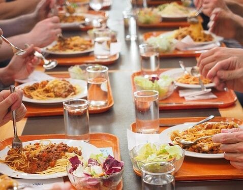 Tables dressées et plats servis au réfectoire de l’école